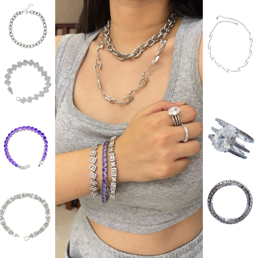 Model wearing layered stainless steel chain necklaces, CZ tennis bracelets in silver and purple, and a triple-band oval CZ ring set